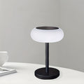 A rechargeable table lamp with smart remote control and dusk-to-dawn activation sensor. This wireless bedside lamp can be powered by solar energy and offers adjustable brightness, perfect for camping.