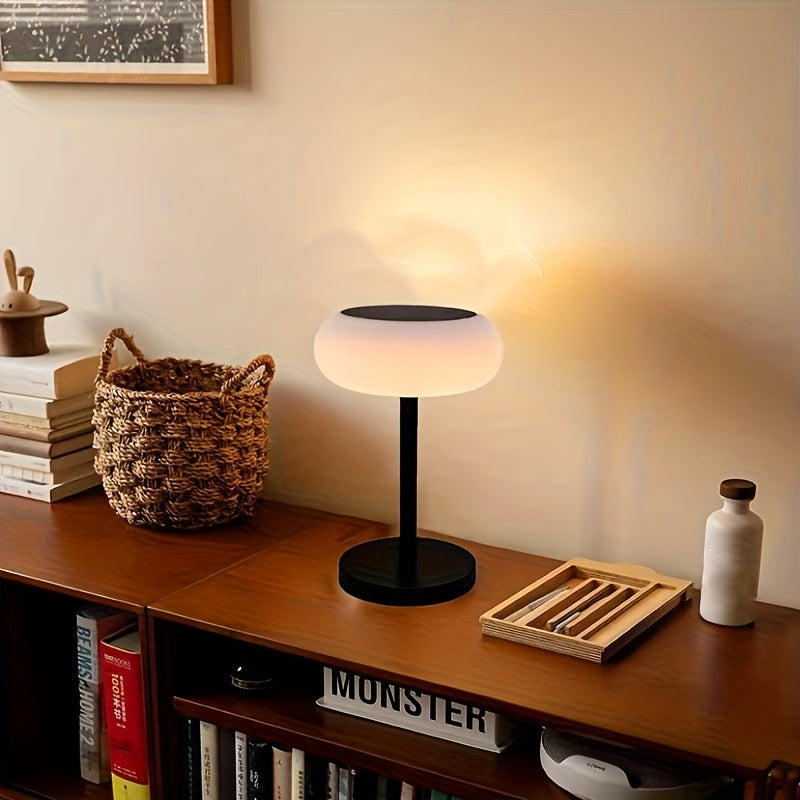 A rechargeable table lamp with smart remote control and dusk-to-dawn activation sensor. This wireless bedside lamp can be powered by solar energy and offers adjustable brightness, perfect for camping.