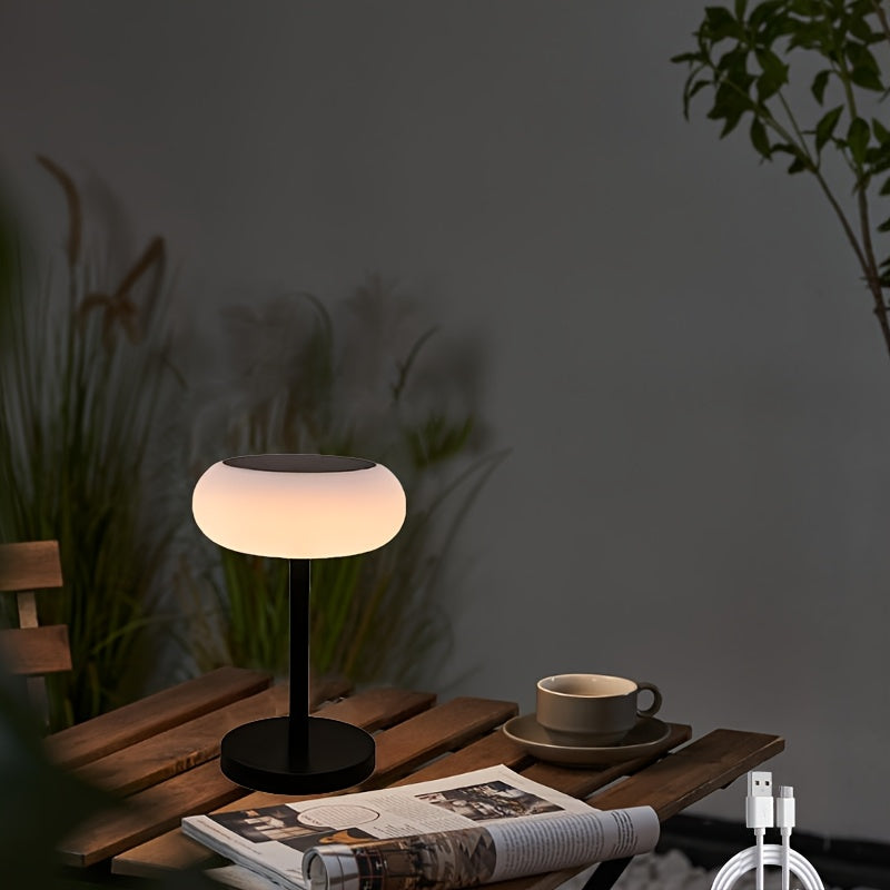 A rechargeable table lamp with smart remote control and dusk-to-dawn activation sensor. This wireless bedside lamp can be powered by solar energy and offers adjustable brightness, perfect for camping.